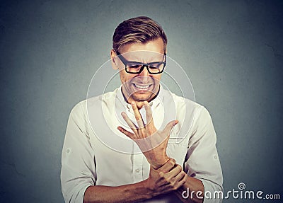 Man holding painful wrist arm. Sprain pain Stock Photo