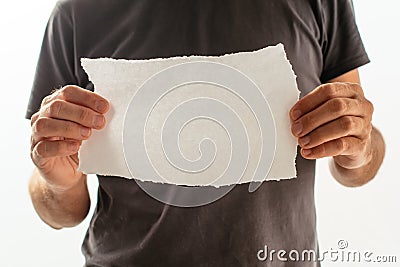 Man holding piece of torn blank paper as copy space Stock Photo