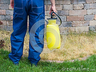 Man holding a plastic yellow portable sprayer Stock Photo