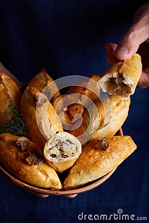 Man holding a plate with delicious small savory pies Stock Photo