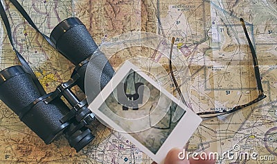 Man holding polaroid photo over a map Stock Photo