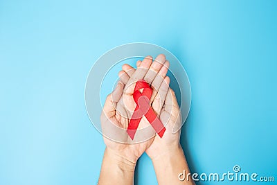 Man holding Red Ribbon for supporting people living and illness. Healthcare and safe sex concept. December World Aids Day Stock Photo