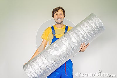 man holding a roll of insulating cloth to install a laminate wooden floor Stock Photo