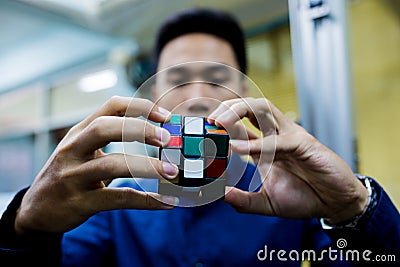 Man holding Rubik`s cube techincal and business solving problem Editorial Stock Photo