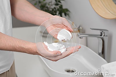 Man holding shaving foam in bathroom, closeup Stock Photo