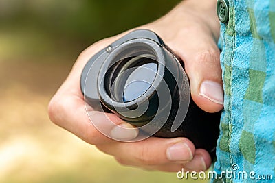 Man holding a simple magnifying monocular glass, modern spy spyglass in hand, object detail, closeup. Spying on someone, stalking Stock Photo