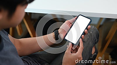 Man holding smart phone while sitting at workspace with crossed legs office. Stock Photo