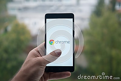 Man holding smartphone with Google chrome with the finger on the screen Editorial Stock Photo