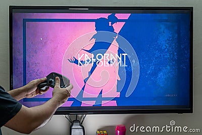 man holding steam controller in front of a screen loading valorant on PC console for gaming showing this popular online Editorial Stock Photo