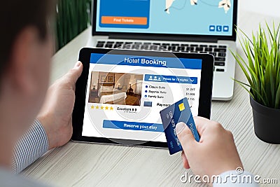 Man holding tablet with app hotel booking screen credit card Stock Photo