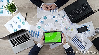 Man holding tablet with green screen, showing company presentation to partner Stock Photo