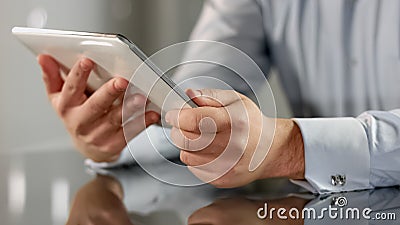 Man holding tablet in hands closeup reading news online, business application Stock Photo