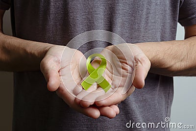 Man holding .turquoise or teal ribbon. Awareness ribbon Stock Photo