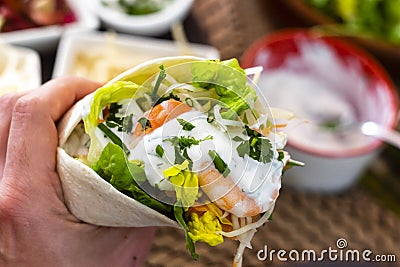 man holding typical Mexican fajita with shrimp and vegetables Stock Photo