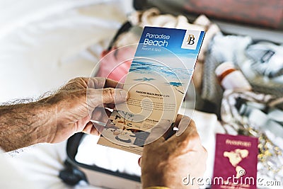 Man holding up beach travels brochure Stock Photo