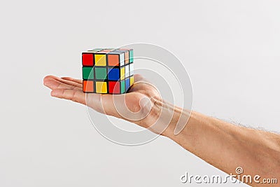 Man holding up an unsolved Rubiks Cube Editorial Stock Photo