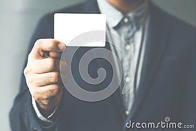 Man holding white business card,Man wearing blue shirt and showing blank white business card. Blurred background. Horizontal mocku Stock Photo