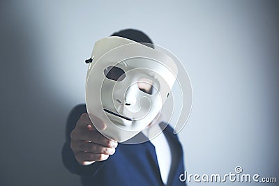 Man holding white mask for hide his face Stock Photo