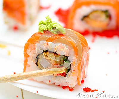 Man holding wooden chopsticks sushin, on top of wasabi sushi. white background Stock Photo