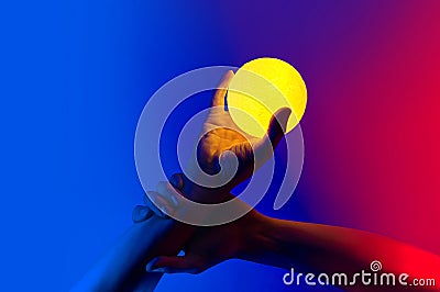 Man holding yellow moon shape illuminated sphere Stock Photo