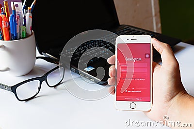 A man holds Apple iPhone 6 with Instagram application on the screen. App is largest and most popular photograph social Editorial Stock Photo