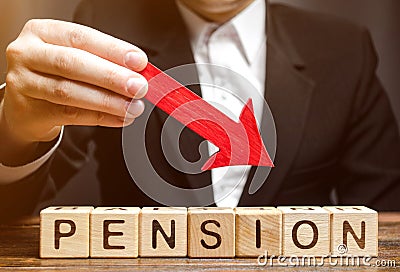 A man holds an arrow down over wooden blocks with the word Pension. Fall / reduction pension payments. Retirement. Financing Stock Photo