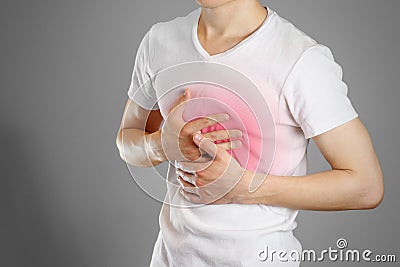 A man holds the Breasts. The pain in his chest. Heartburn. Stock Photo