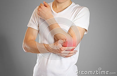 A man holds the elbow. The pain in my arm. A sore point in red. Stock Photo