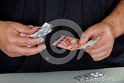 Man holds in his hands the drugs and money social problems expensive medicine Stock Photo