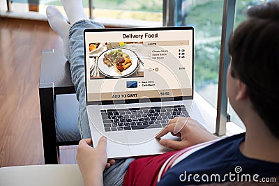 Man holds laptop with food delivery application on the screen Stock Photo