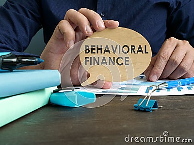 Man holds plate with behavioral finance words. Stock Photo