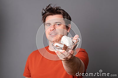 Man holds a plate of chocolate ice cream. Funny man with an appetite eats ice cream Stock Photo