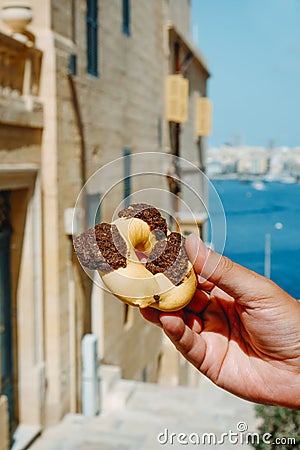 Man holds a qaghaq tal-ghasel in Malta Stock Photo