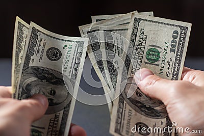 A man holds stack hundred-dollar bills in his hands close-up Stock Photo