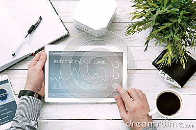 Man holds tablet pc with electric energy usage application Stock Photo