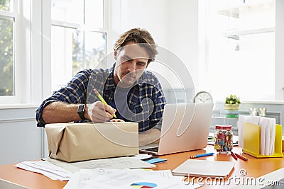 Man At Home Addressing Package For Mailing Stock Photo