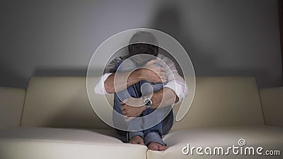 Man at home in despair - young depressed and desperate man crying on sofa couch confused and troubled suffering depression problem Stock Photo