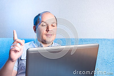 Man at home in front of laptop. During online communication, an idea. An idea came up during online communication Stock Photo