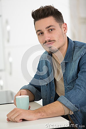 man at home holding hot drink Stock Photo