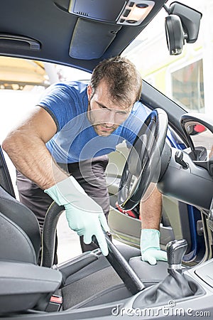 Man hoovering the car cabin, cleaning concept. Stock Photo