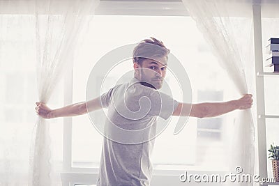 Man and hope concept - man opening window with looking camera curtains business concept. Stock Photo