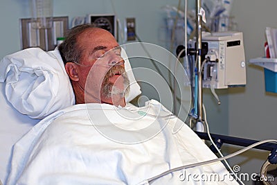 Man in hospital bed asleep Stock Photo