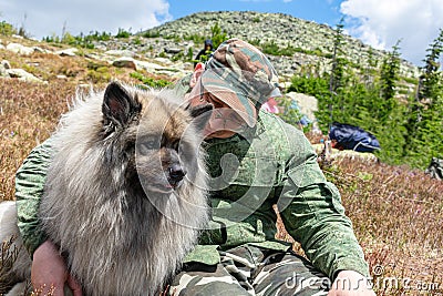 Man hugs his beloved dog while walking in the mountains Stock Photo