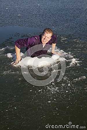 Man in ice hole climb out Stock Photo