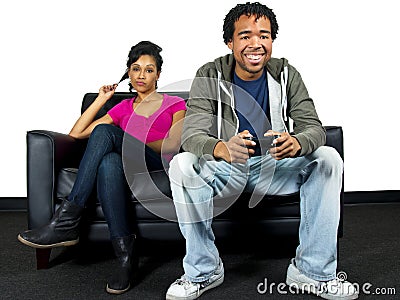 Man ignoring girlfriend while playing video games Stock Photo