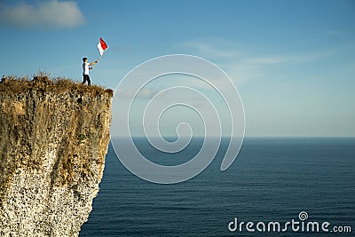 Man with indonesian flag of indonesia on top of the mountain Stock Photo