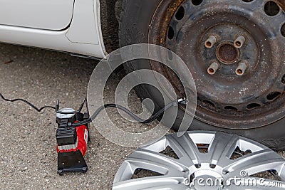 Man inflates tire with air and checking air pressure with gauge pressure in service station. Flat tire concept Stock Photo