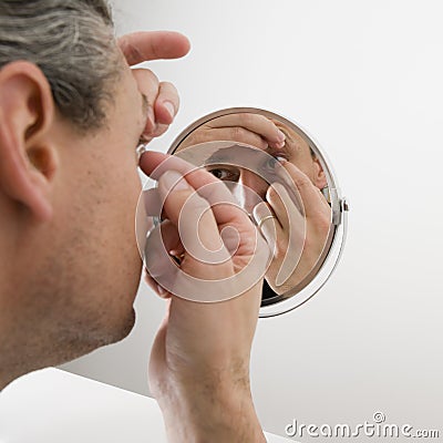 Man inserting a contact lens Stock Photo