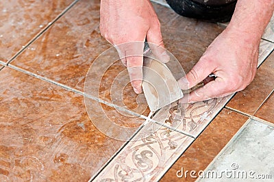 Man installing floor tile Stock Photo