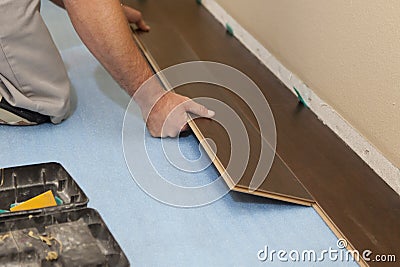 Man Installing New Laminate Wood Flooring Stock Photo